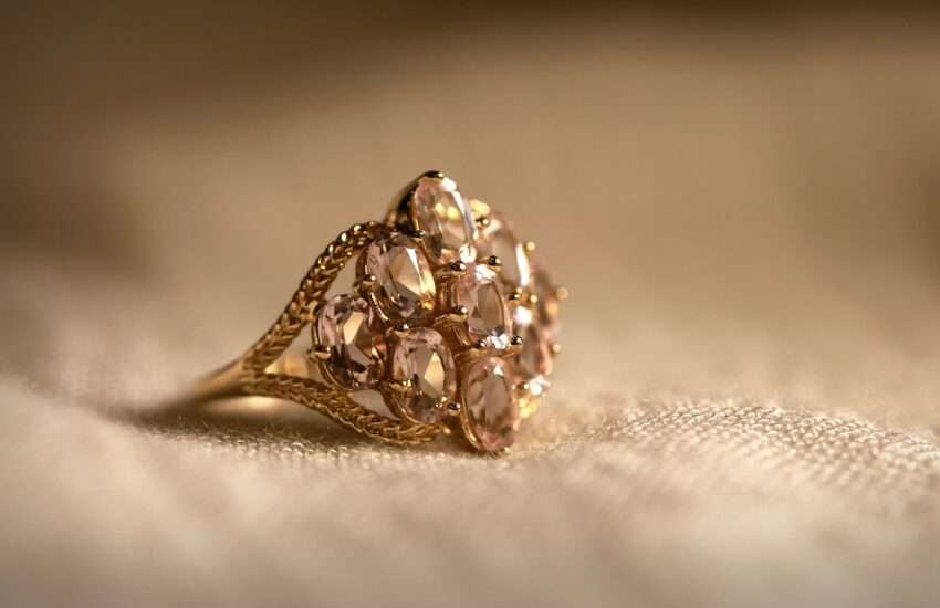 gold diamond studded ring on white textile